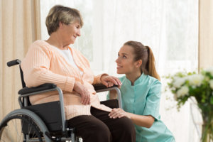 Elderly woman in wheelchair and hospice helper
